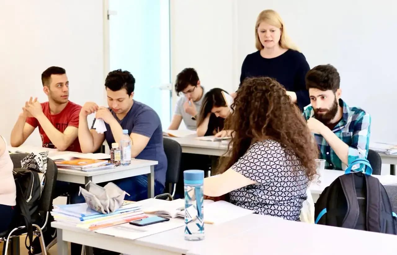A teacher supporting a group of German learners